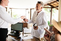 Resort receptionist giving a room key to a guest