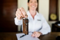 Receptionist handing room key to guest