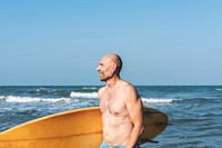 A man with a surfboard by the coast