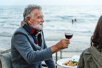 Seniors toasting with red wine at the beach