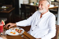 Senior man having breakfast at a hotel