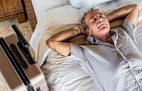 Senior man sleeping on a white bed