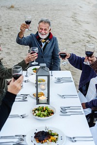 Mature friends having a dinner party at the beach