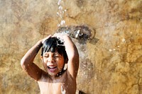 Little boy taking a shower by a swimming pool