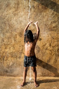 African kid showering in outdoor shower