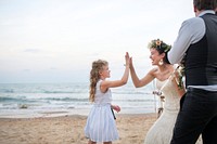 Bride giving a girl a high five at the beach wedding