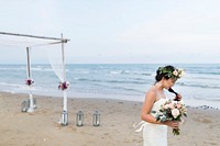 Bride holding a bouquet at the beach