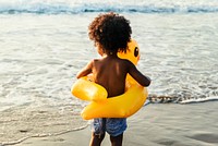 Cute toddler with duck tube on the beach