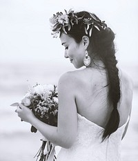Back of a bride holding a bouquet of flowers