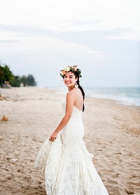 Young bride in her wedding dress on the beach