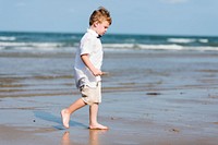 Little boy walking at the beach