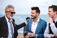 Men talking at a beach wedding