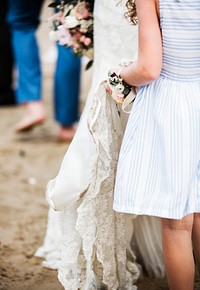 Flower girl holding bridal wedding dress