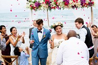 Cheerful newlyweds at beach wedding ceremnoy