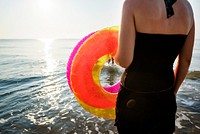 Woman carrying a swimming ring to the beach