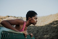 Woman stretching against a park bench