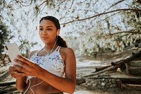 Active woman listening to music through earphones