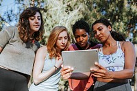 Group of active women looking at a digital tablet