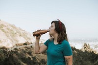 Woman drinking water while trekking