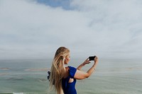 Blonde woman taking a photo with her phone
