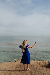 Blonde woman taking a photo with her phone