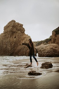 Woman standing on a rock at the beach
