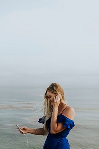 A woman listening to music at a beach