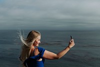 Blonde woman taking photos with her phone