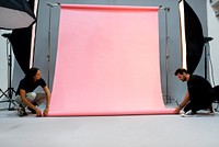 Camera crew setting up the backdrop for a photo shoot