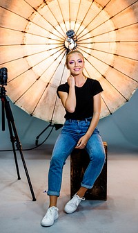 Model posing in front of a reflective umbrella in a studio