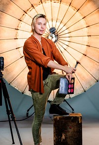 Makeup artist posing in front of a reflective umbrella in a studio