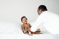 Dad playing with his baby on the bed