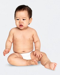 Baby in a diaper sitting on the floor