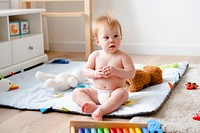 Baby in a diaper playing with toys
