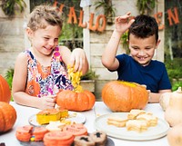 Young kids carving Halloween jack-o&#39;-lanterns