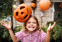 Young playful girl with her Halloween jack-o&#39;-lantern