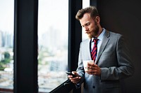 Businessman using a phone and drinking coffee