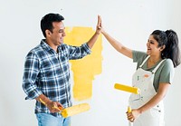 Couple giving a high five while renovating their new house