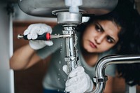 Woman fixing a kitchen sink