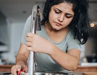 Woman fixing the kitchen sink