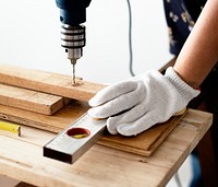 Woman drilling into a wooden plank