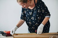 Woman measuring a wooden plank