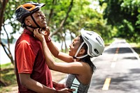 Woman fastens a bike helmet for her boyfriend