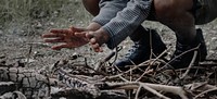 Warming hands by the campfire ashes