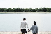 Couple holding hands by the lake