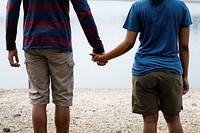 Cheerful couple holding hands by the lake