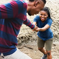 Man helping his girlfriend on a trek