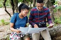Trekking couple using a map in a forest