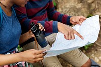 Trekking couple using a map in a forest