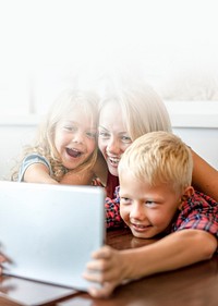 Blonde mom and kids making a video call on a tablet text space